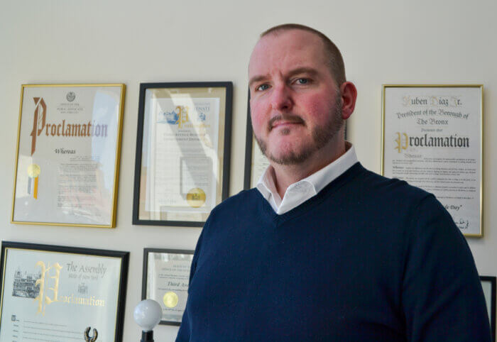 Michael Brady in his office in front of framed proclamations