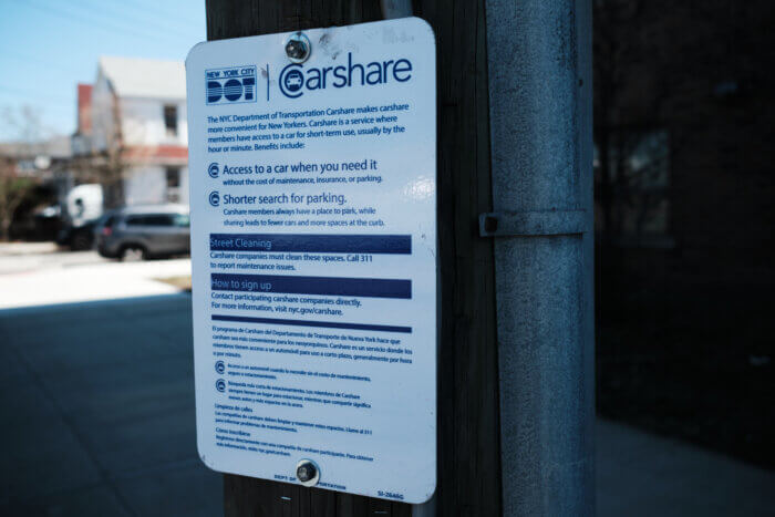 a sign from DOT on a pole explaining the carshare program