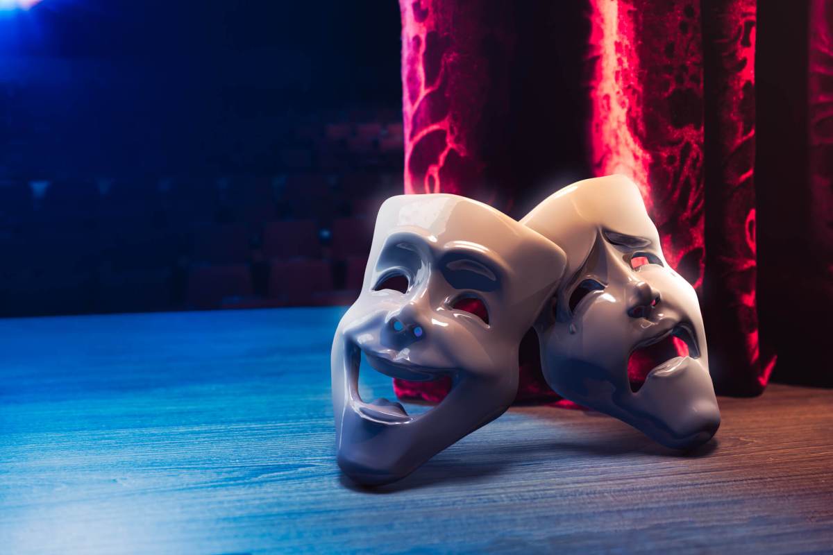 Theater masks in front of a red curtain