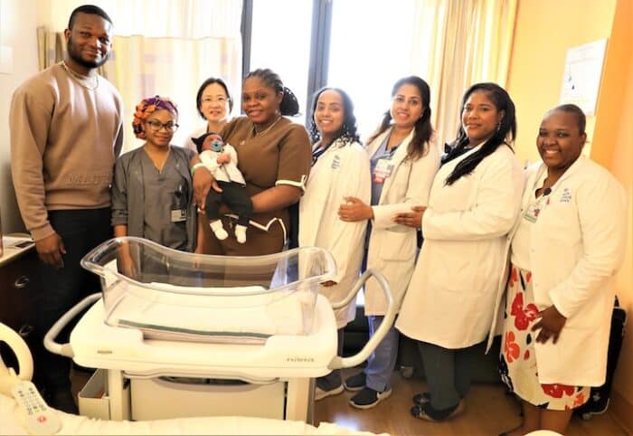 Ayomide Olatunde holds her son Lotunna while surrounded by staff at North Central Bronx hospital.