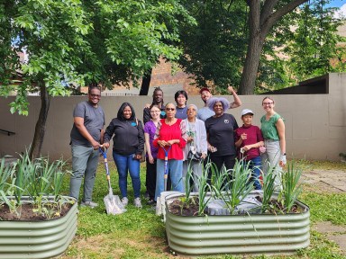 Camber Property Group, Phyllis Harris, and volunteers plant a community garden in Twin Parks. Photo courtesy Camber Property Group