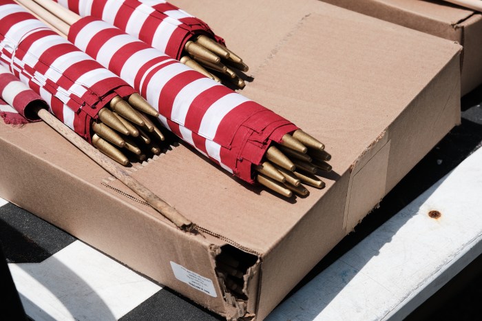 Small boxed and rolled American flags lay on the back of a golf cart waiting to be planted by volunteers on May 20, 2024.