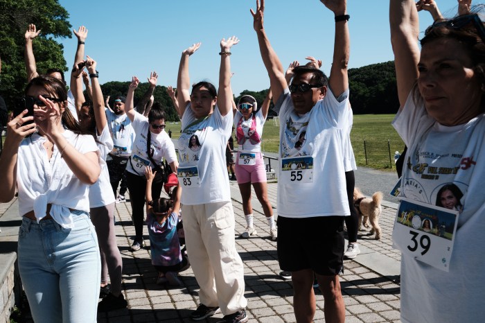 Runners and walkers stretch before running or walking the Cristian Rivera Foundation's 7th Annual Full Steam Ahead 5K in Van Cortlandt Park on June 15, 2024.