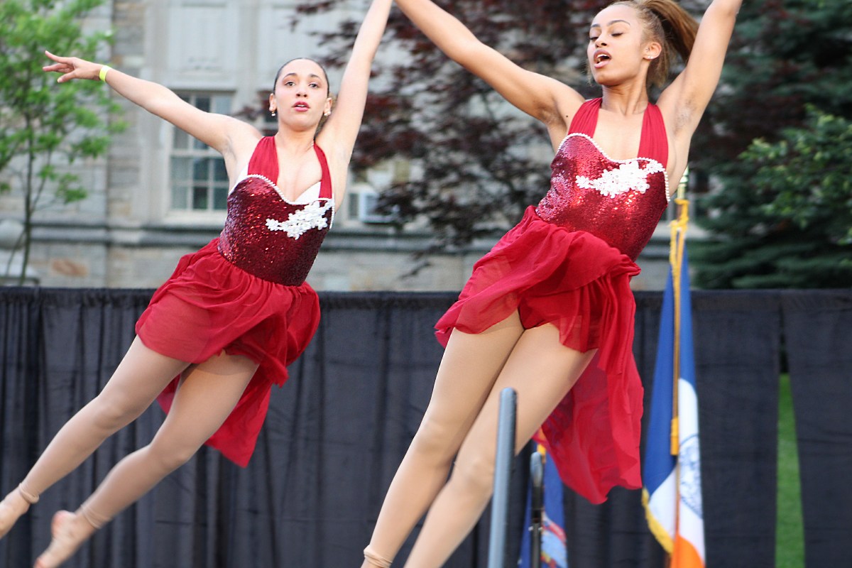Alyssa Bowman (l.) and Hazel Avila fly through the air as they perform at the first-ever, Lehman's Got Talent during the college's Spring Fling fundraiser.