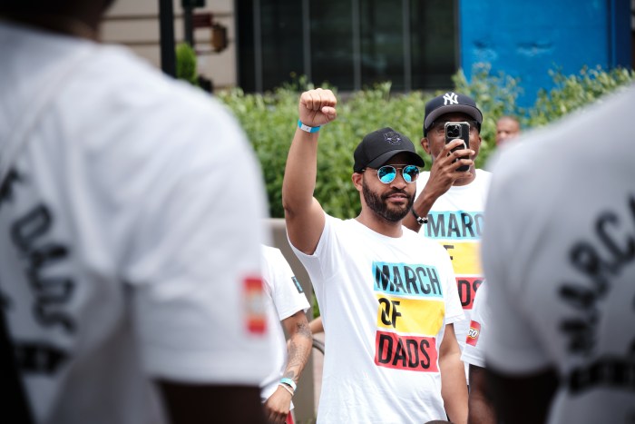 A father makes a fist before the March of Dads held by Dad Gang in Mill Pond Park on June 29, 2024.