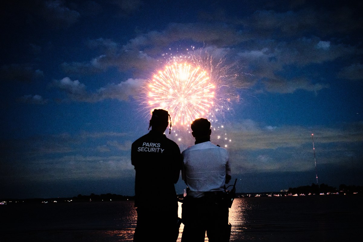 People take a moment to admire the fireworks during this year's annual Salute to the Land of the Free Fireworks Extravaganza at the Bronx's Orchard Beach on June 27, 2024.